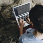 White man using computer laptop at waterfall